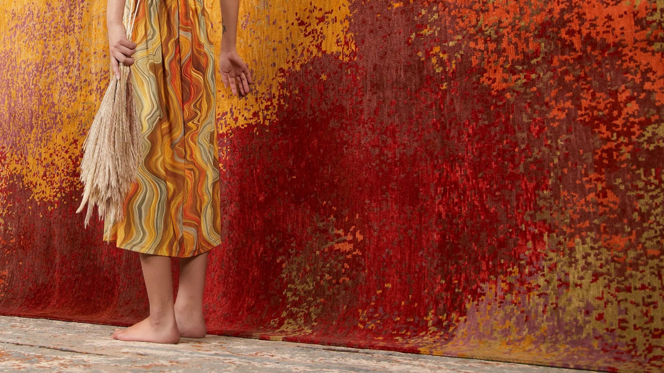 A big carpet hanging and a women walking past.