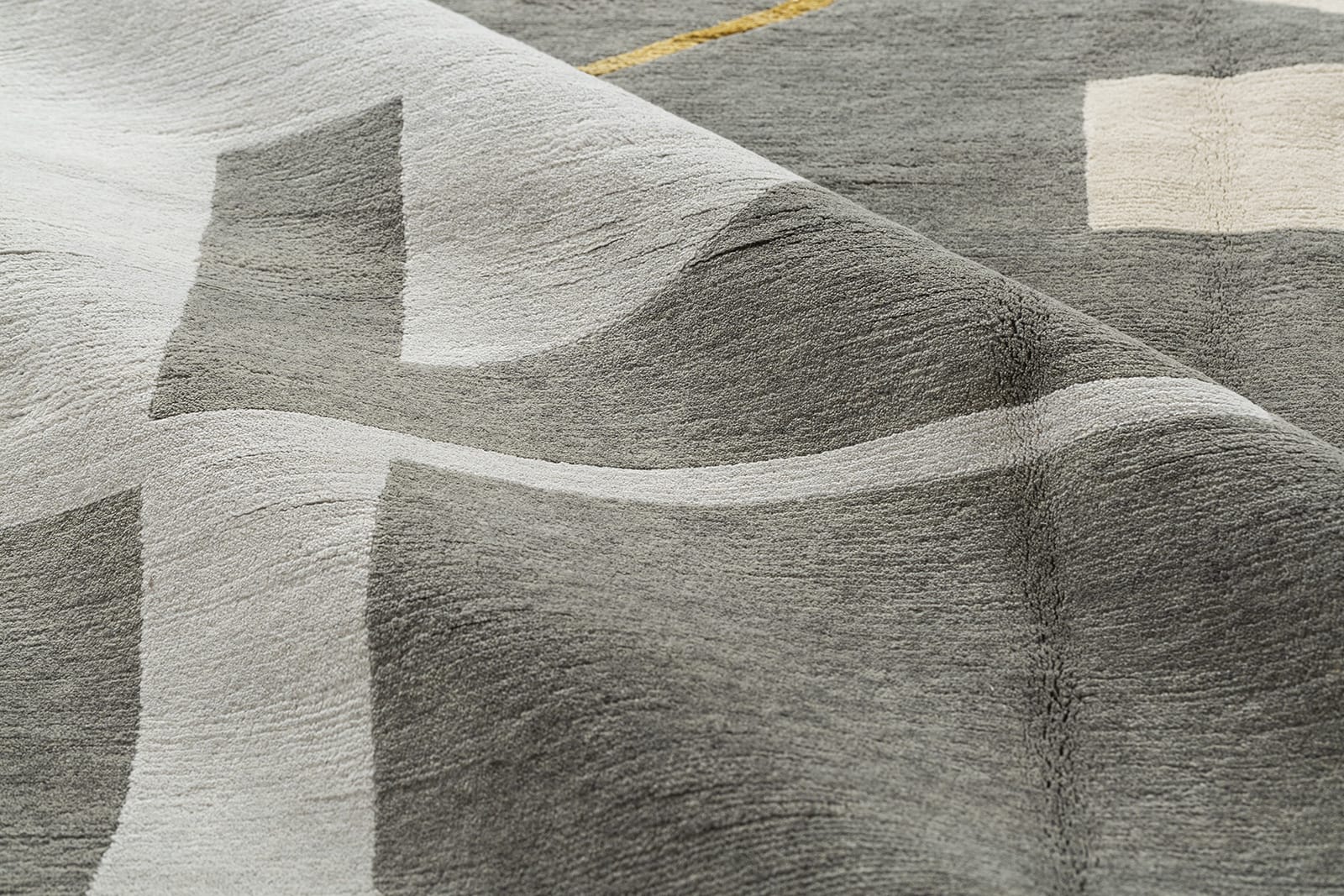 detail image of Talking Heads Grey hand knotted area rug design by Tufenkian