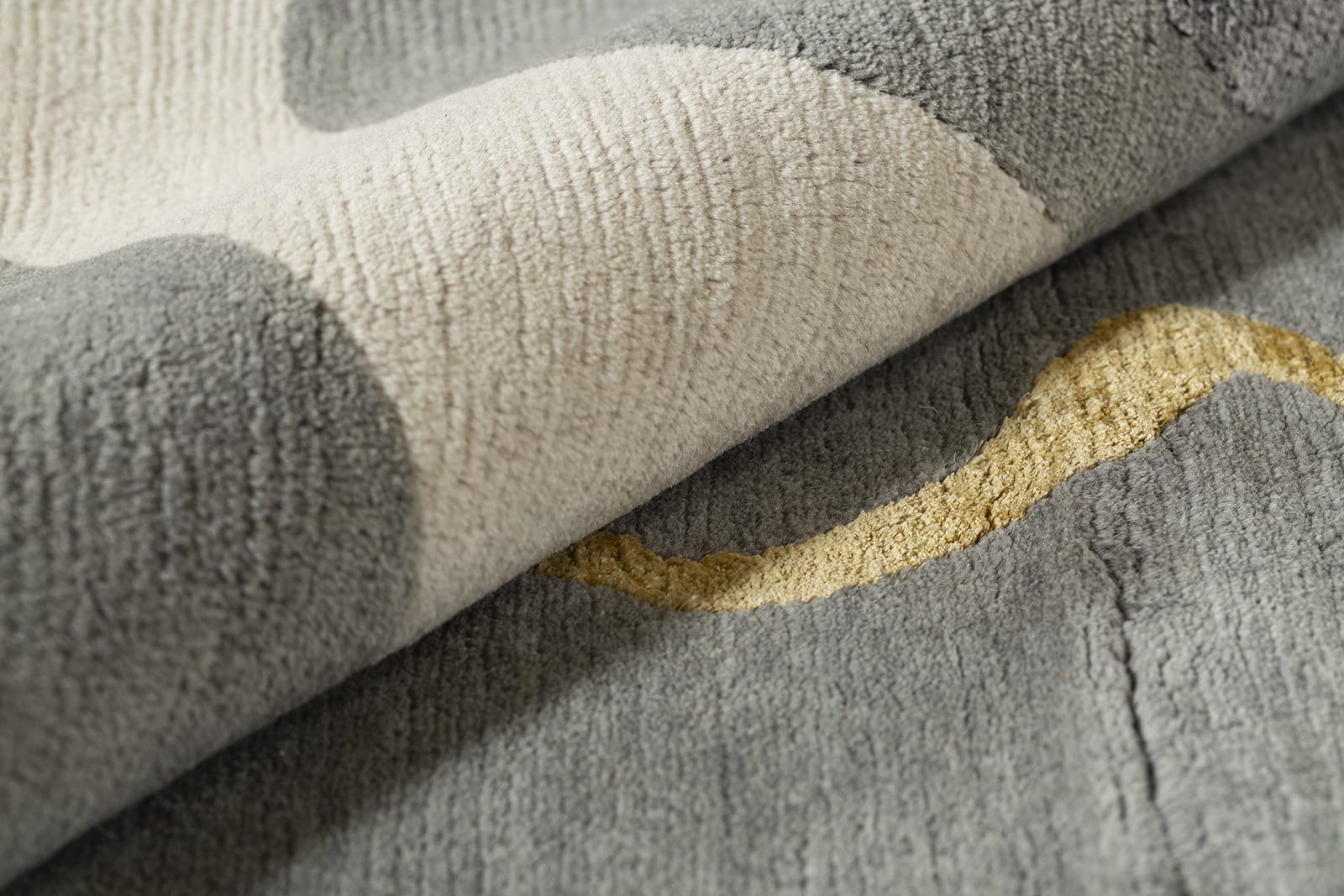 detail image of Talking Heads Grey hand knotted area rug design by Tufenkian